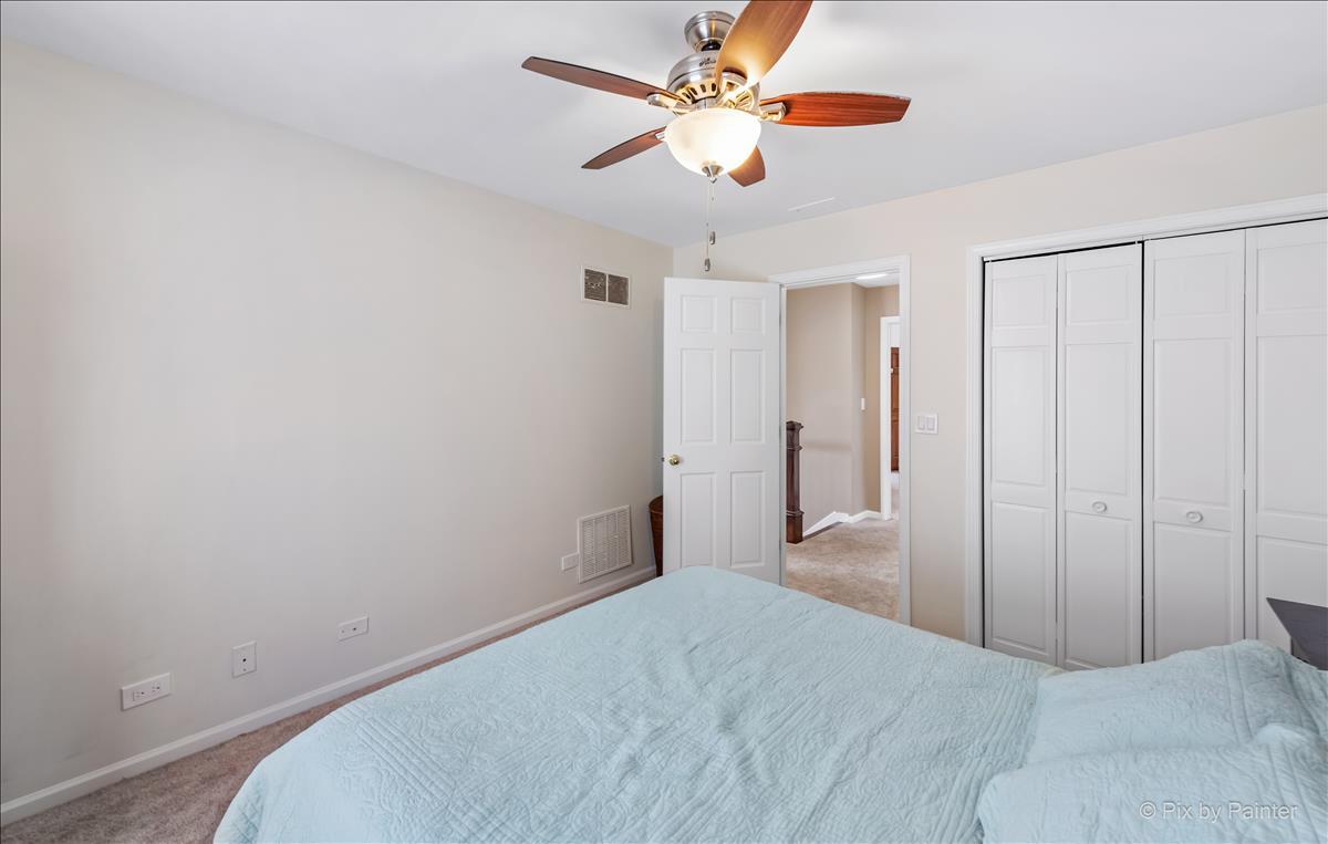 254 Perth Road Cary, IL 60013 - Photo 22 of 36 a bedroom with a bed and a chandelier