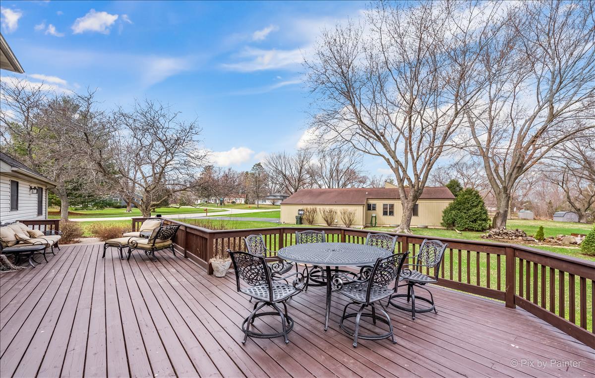 254 Perth Road Cary, IL 60013 - Photo 30 of 36 a view of a roof deck with table and chairs couches and a barbeque with wooden fence and floor