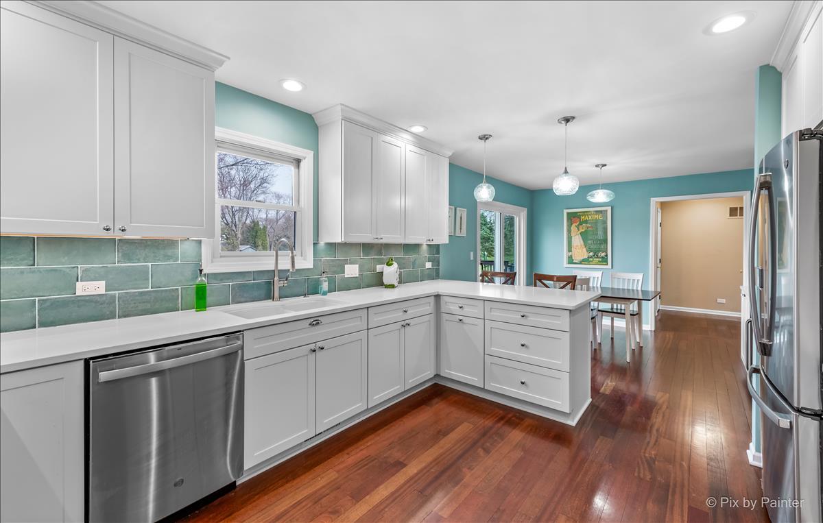 254 Perth Road Cary, IL 60013 - Photo 9 of 36 a kitchen with sink cabinets and wooden floor