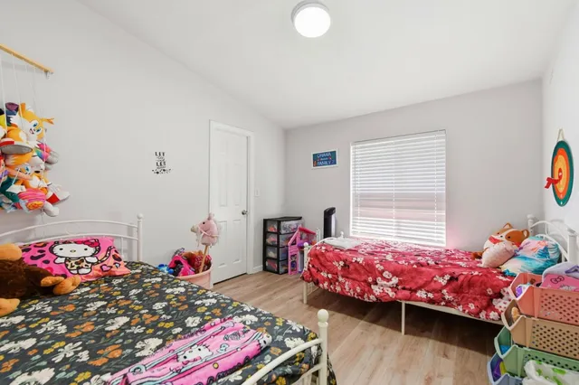 a bedroom with a bed and a lamp on dresser