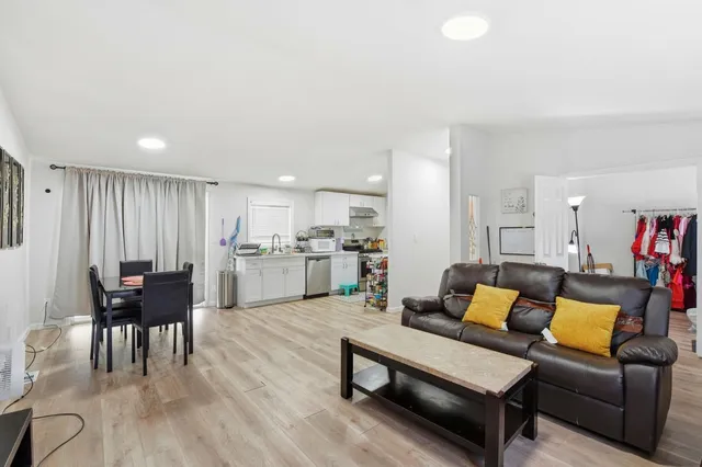 a living room with furniture and a dining table with kitchen view