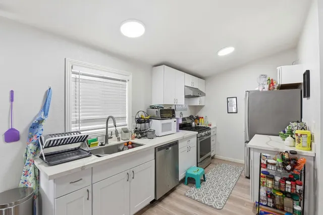 a kitchen that has a sink cabinets and window