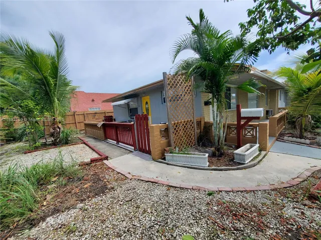a view of a house with a yard and sitting area