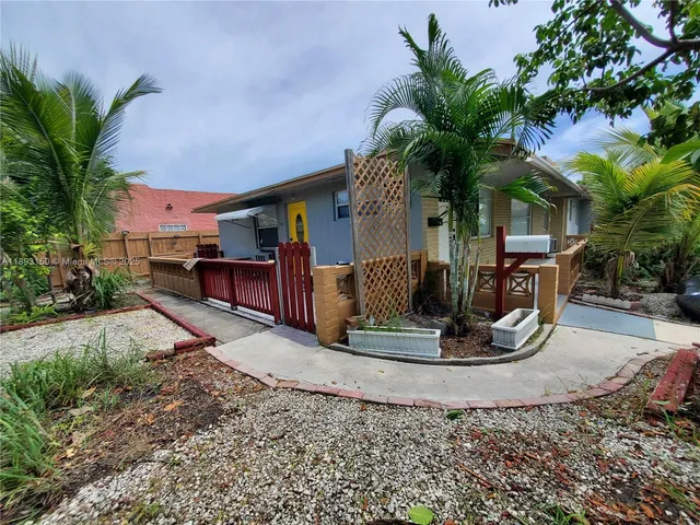 a view of a house with a yard and potted plants