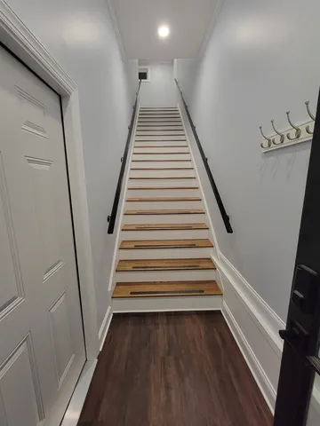 an empty room with wooden floor and a ceiling fan