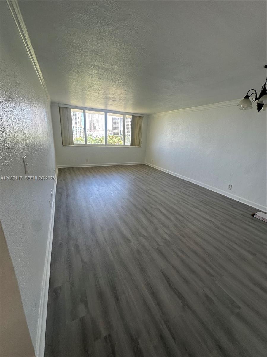 9001 Southwest 77th Avenue, Unit C702 Miami, FL 33156 - Photo 3 of 11 wooden floor in an empty room with a window