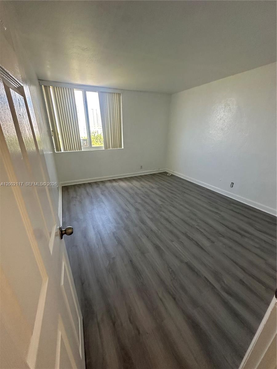 9001 Southwest 77th Avenue, Unit C702 Miami, FL 33156 - Photo 4 of 11 wooden floor in an empty room with a window