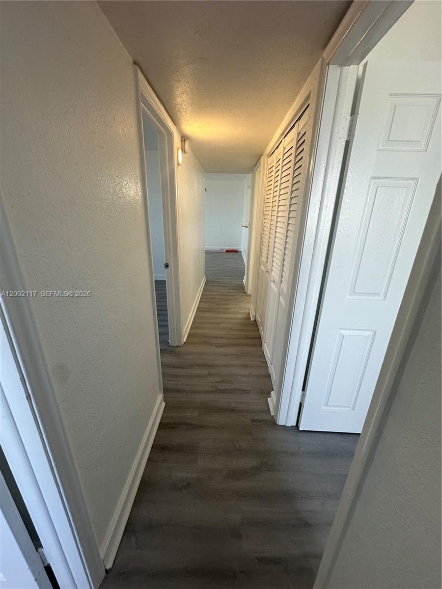 9001 Southwest 77th Avenue, Unit C702 Miami, FL 33156 - Photo 5 of 11 a view of a hallway with wooden floor and staircase