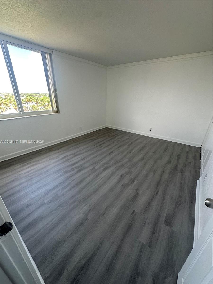 9001 Southwest 77th Avenue, Unit C702 Miami, FL 33156 - Photo 6 of 11 an empty room with wooden floor and windows