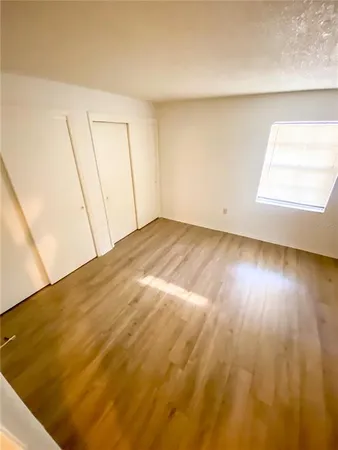 a view of empty room with wooden floor