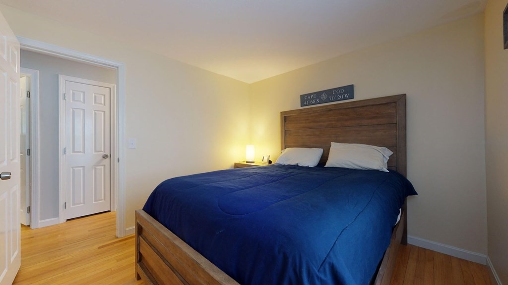 290 Riverview Lane Barnstable, MA 02632 - Photo 16 of 31 a bedroom with a bed lamp and wooden floor