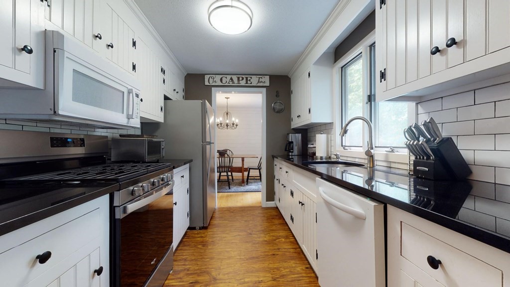 290 Riverview Lane Barnstable, MA 02632 - Photo 23 of 31 a kitchen with granite countertop white cabinets and black appliances