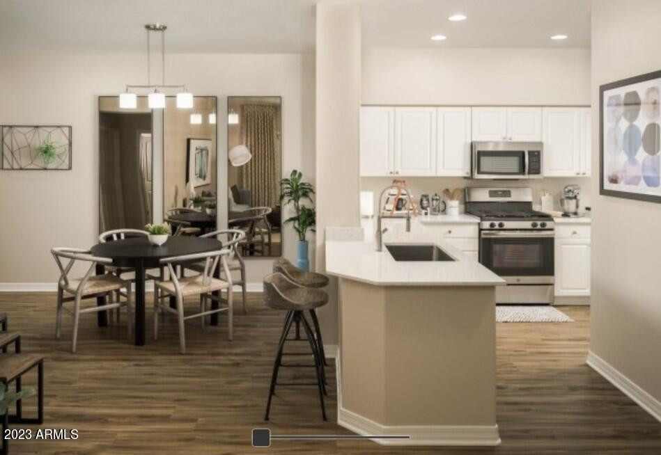 2910 South Greenfield Road, Unit B3B Gilbert, AZ 85295 - Photo 4 of 13 a kitchen with stainless steel appliances a dining table chairs stove and refrigerator