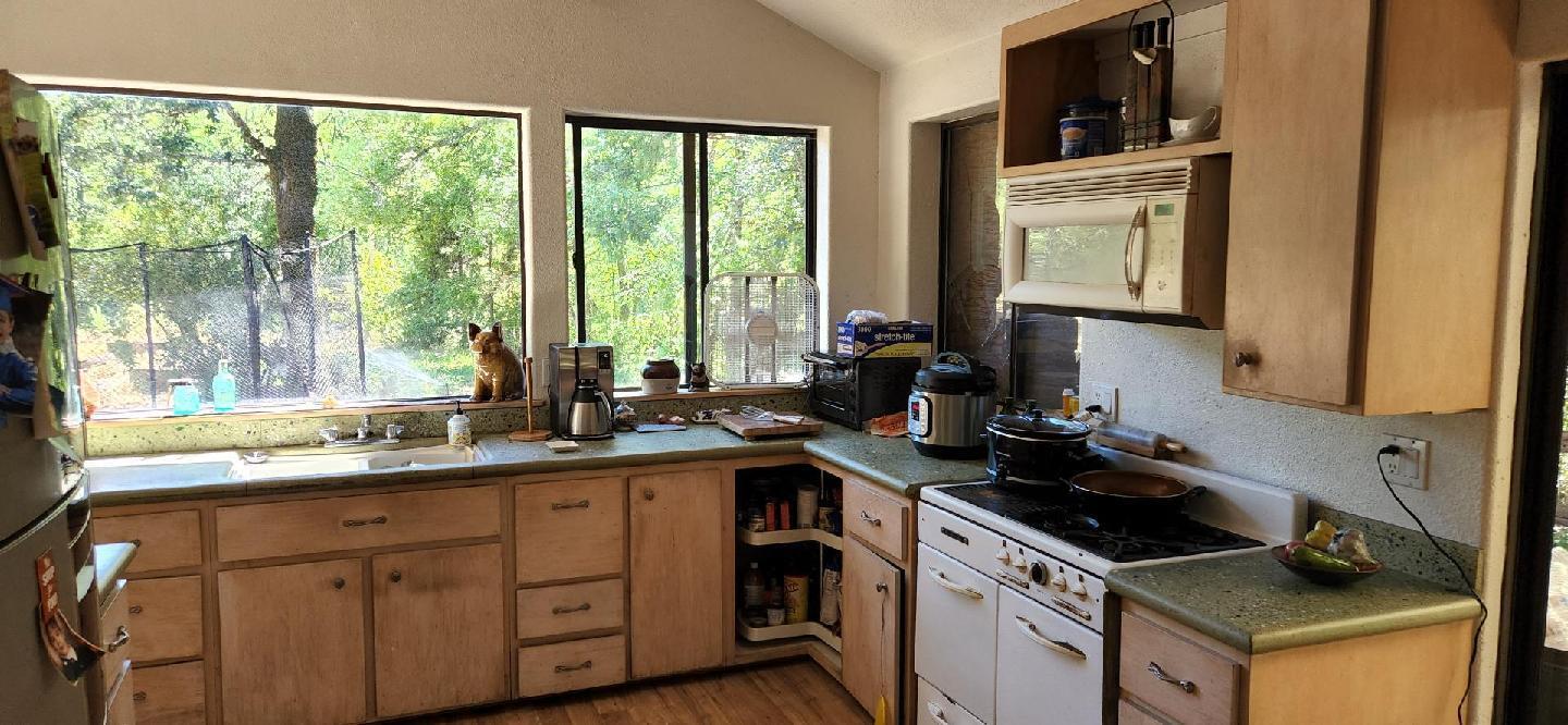 12100 Takilma Road Cave Junction, OR 97523 - Photo 11 of 20 a kitchen with a sink stove and cabinets