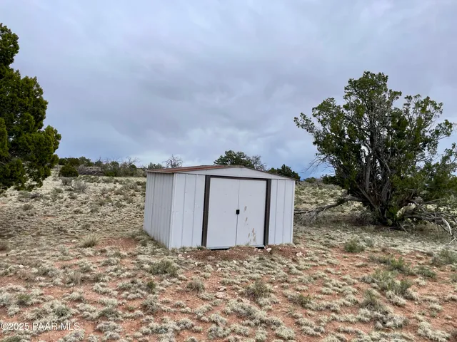 a view of a dry yard with a house in the background