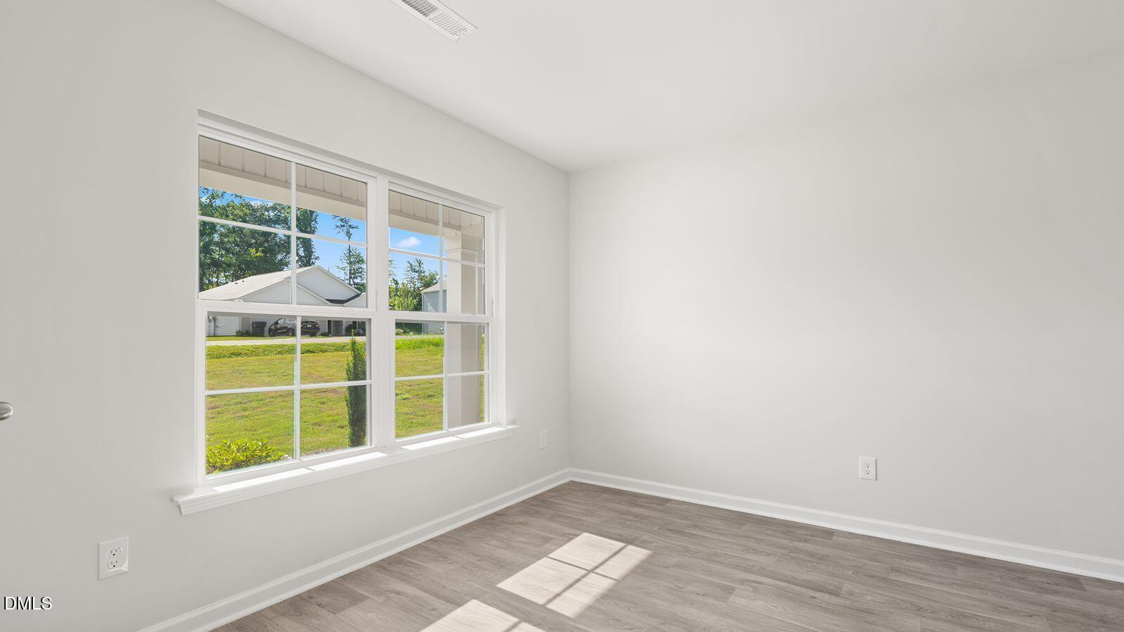 122 Daniel Road Smithfield, NC 27577 - Photo 2 of 22 an empty room with wooden floor and windows