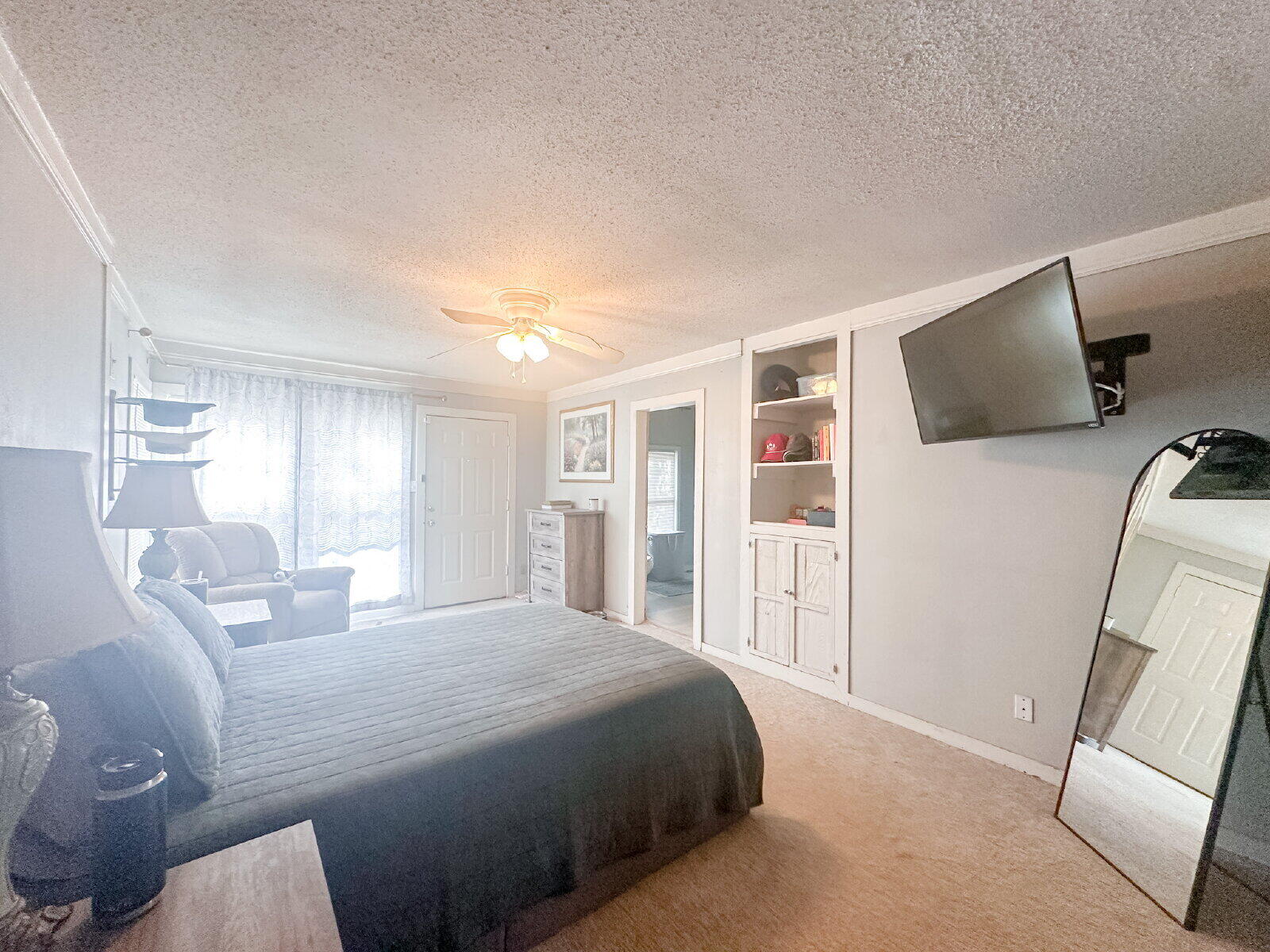 2611 29th Street Lubbock, TX 79410 - Photo 8 of 9 a bedroom with a bed a flat screen tv and a large window
