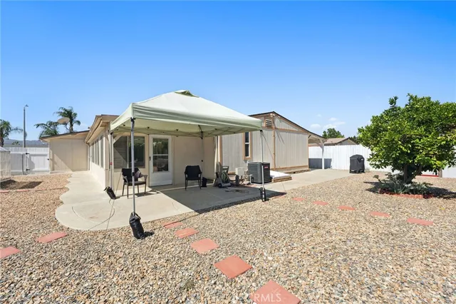a view of a patio with table and chairs under an umbrella