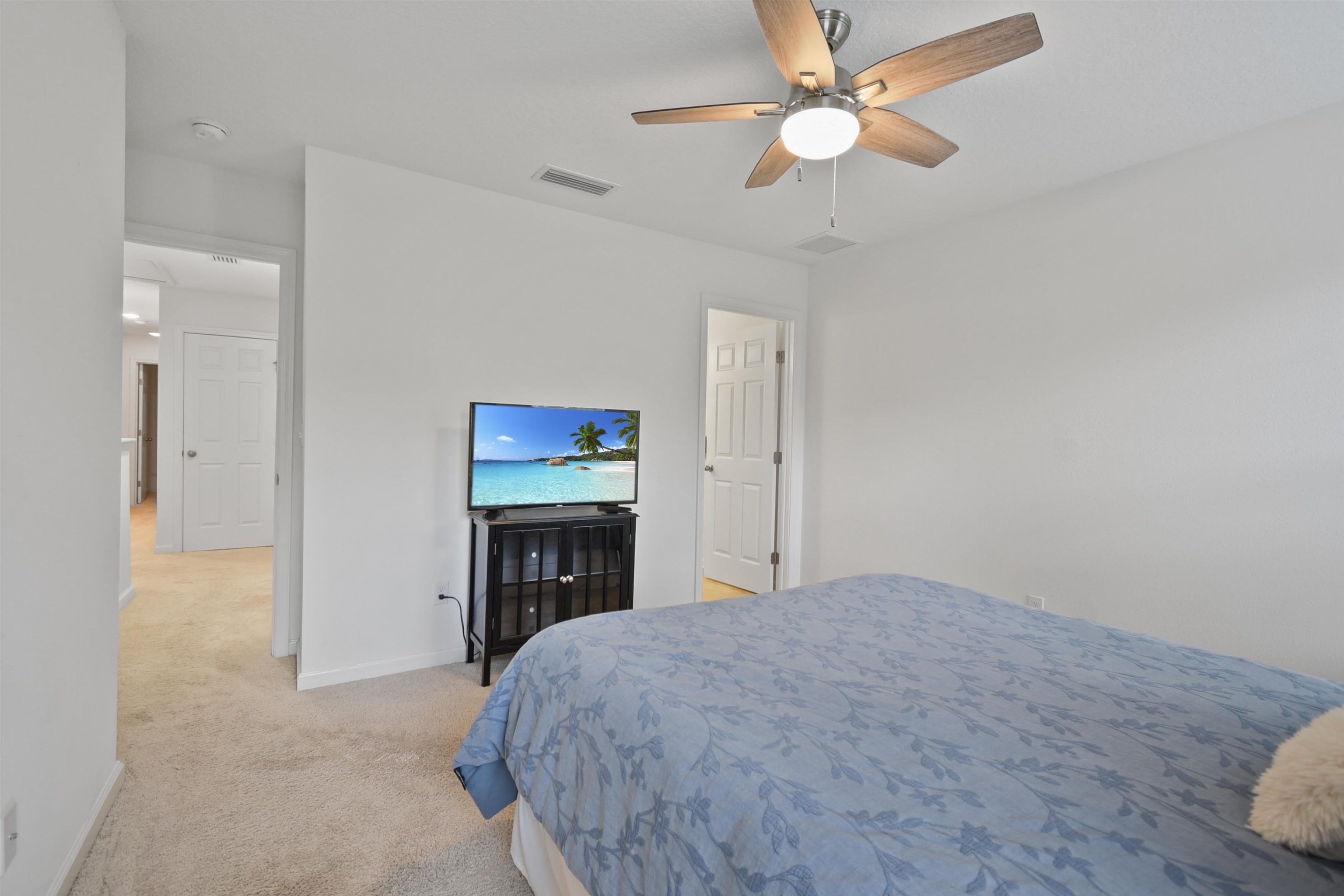 105 Ridge Lake Road St. Augustine, FL 32086 - Photo 18 of 34 a bedroom with a bed and a chandelier