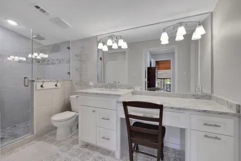 a bathroom with a sink a toilet a light fixture and mirror