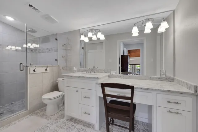 a bathroom with a sink a toilet a light fixture and mirror