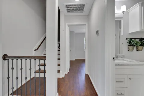 a view of a hallway with wooden floor and staircase