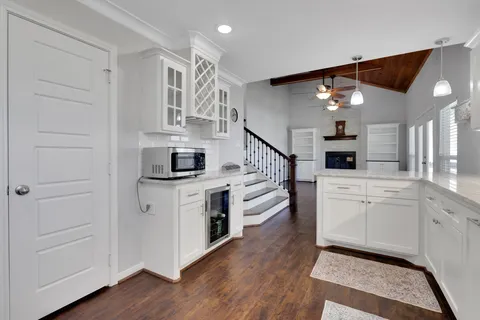 a kitchen with cabinets and wooden floor