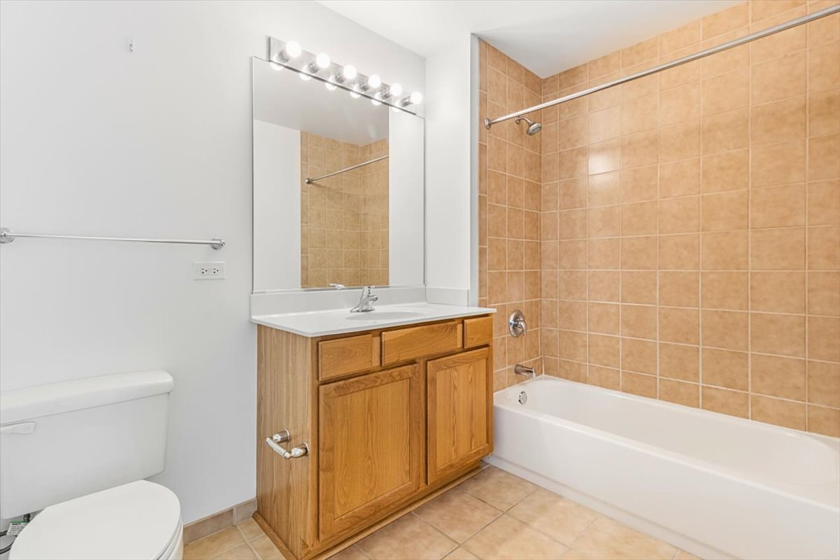 1600 South Indiana Avenue, Unit 908 Chicago, IL 60616 - Photo 25 of 26 a bathroom with a granite countertop sink a mirror and a bathtub