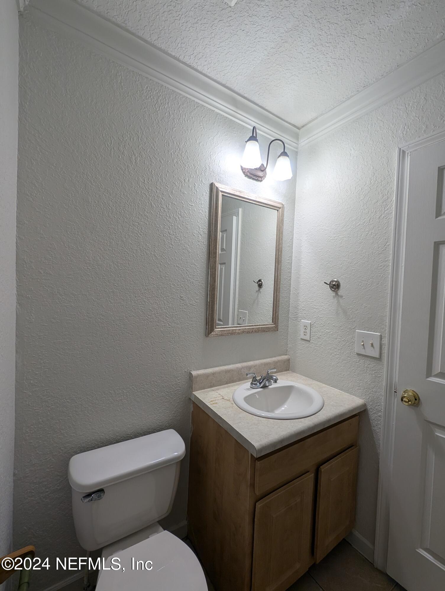 114 Cedar Street, Unit 8 St. Augustine, FL 32084 - Photo 25 of 39 a bathroom with a toilet sink and mirror