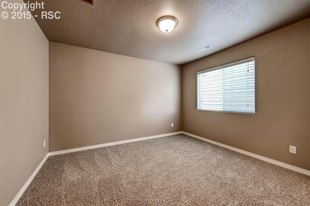 944 Diamond Rim Drive Colorado Springs, CO 80921 - Photo 22 of 28 Spacious bedroom facilitating cozy living.