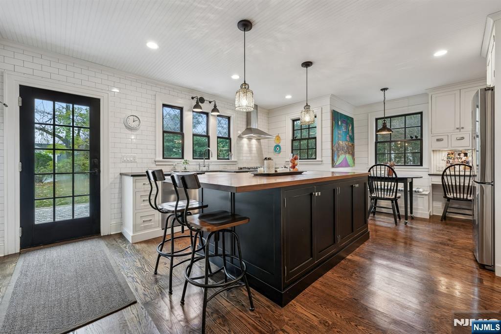 54 Joyce Road Tenafly, NJ 07670 - Photo 12 of 35 a dining hall with stainless steel appliances kitchen island a table chairs and a large window