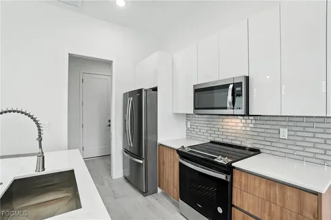 a kitchen with stainless steel appliances granite countertop a refrigerator and a stove top oven