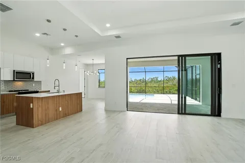 a large kitchen with stainless steel appliances granite countertop a large counter top a sink with wooden cabinets and glass door