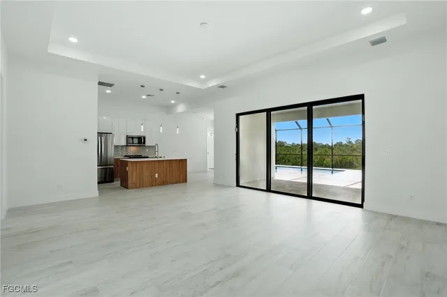 a view of a big room with wooden floor and windows