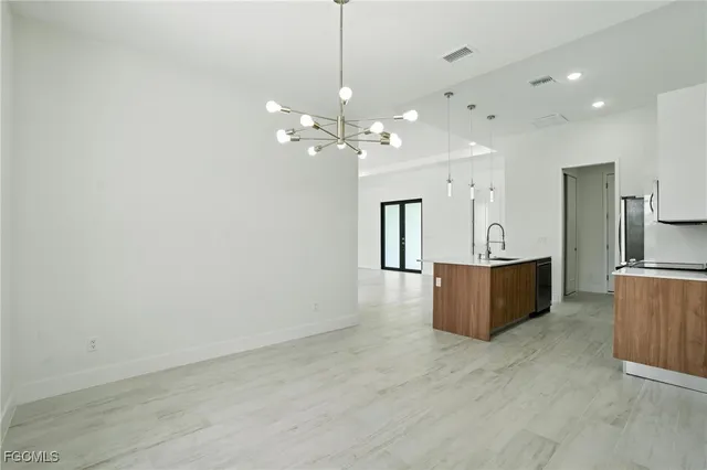 a view of a kitchen with granite countertop a sink a refrigerator and a stove