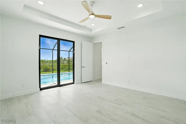 an empty room with ceiling fan and window