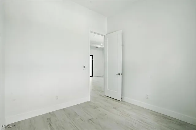 an empty room with wooden floor and ceiling fan