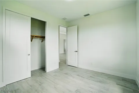 an empty room with wooden floor and a bathroom