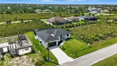 an aerial view of residential houses with outdoor space and trees