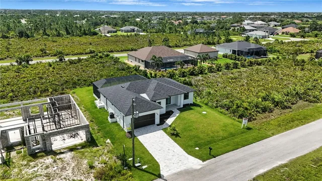 an aerial view of residential houses with outdoor space and trees