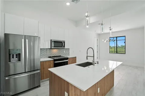 a kitchen with kitchen island a sink stainless steel appliances and refrigerator
