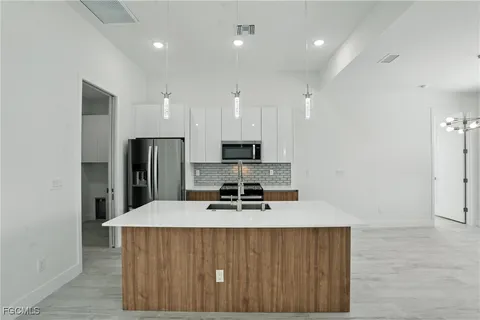 a kitchen with stainless steel appliances a refrigerator and a stove top oven