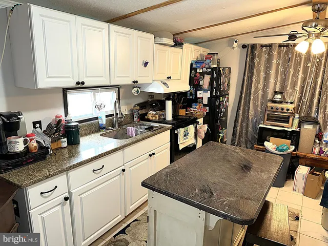 a kitchen with stainless steel appliances granite countertop a sink refrigerator and cabinets