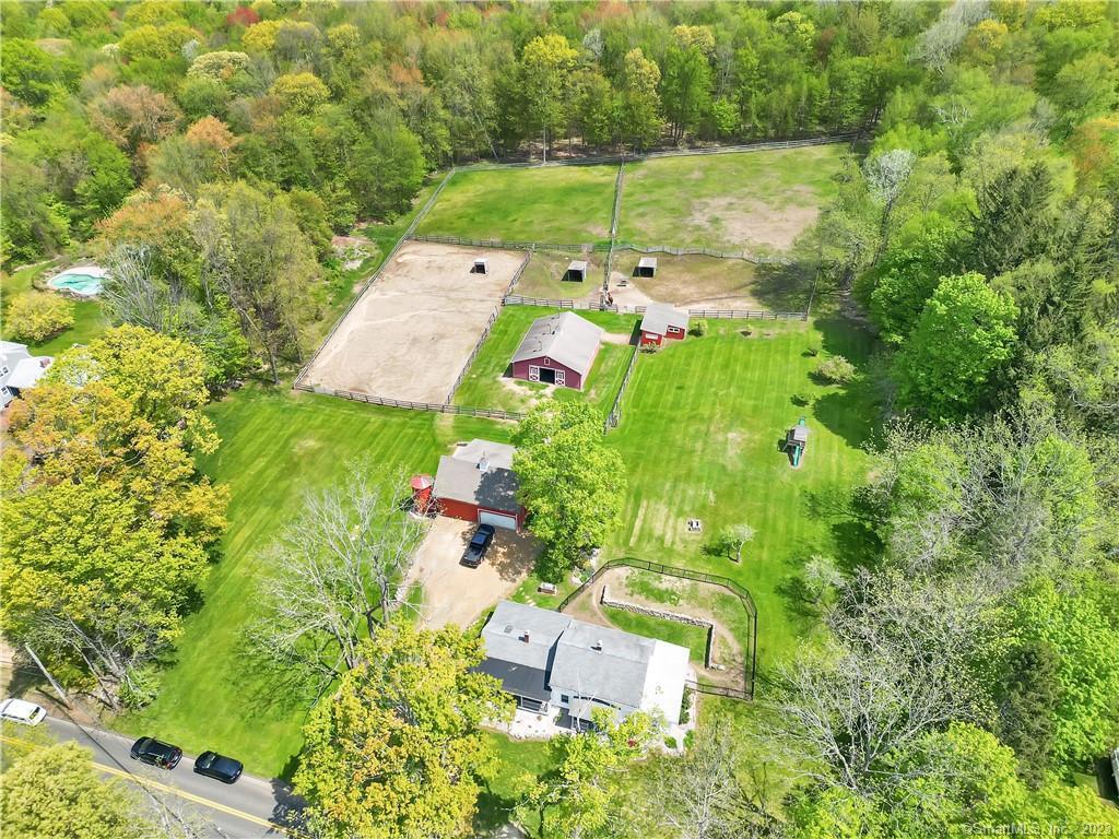 an aerial view of residential house with outdoor space and trees all around
