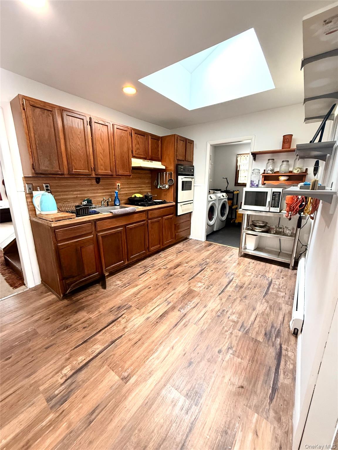 22 Blue Point Road Mastic Beach, NY 11951 - Photo 6 of 29 a kitchen with stainless steel appliances wooden floor and a refrigerator