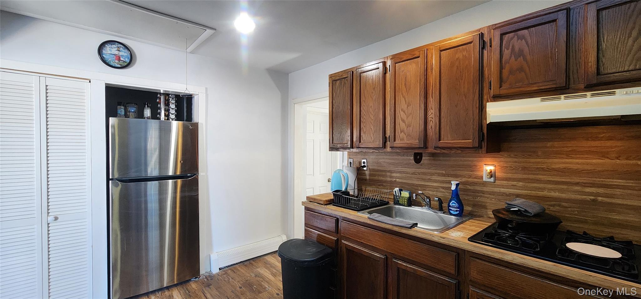 22 Blue Point Road Mastic Beach, NY 11951 - Photo 7 of 23 a kitchen with a sink a refrigerator and cabinets