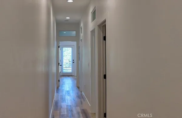 an empty room with wooden floor and a bathroom