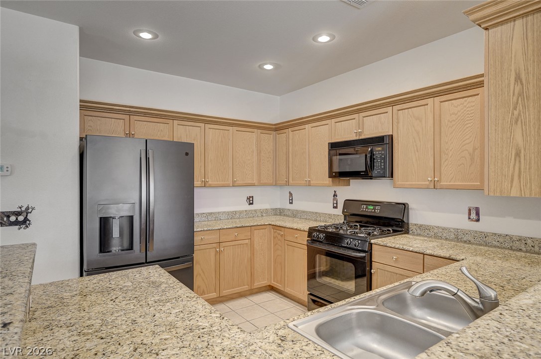 1479 Orange Jubilee Road Henderson, NV 89014 - Photo 11 of 36 A well-appointed kitchen showcasing light wood cabinetry and substantial counter space.