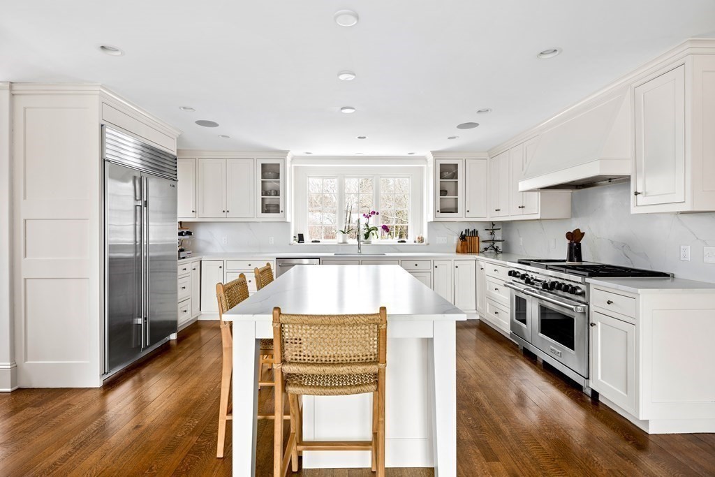 15 Old Neck Road Manchester, MA 01944 - Photo 11 of 24 a kitchen with stainless steel appliances kitchen island granite countertop a stove a sink a refrigerator and white cabinets with wooden floor