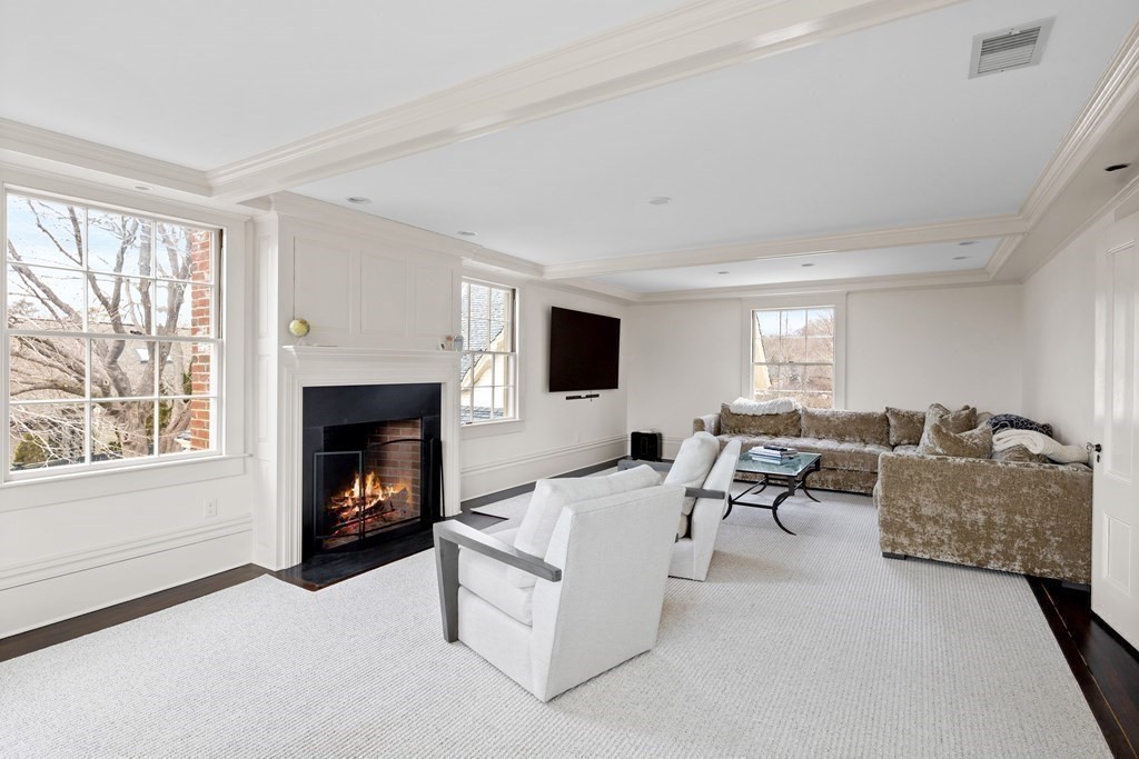 15 Old Neck Road Manchester, MA 01944 - Photo 16 of 24 a living room with furniture flat screen tv and a fireplace